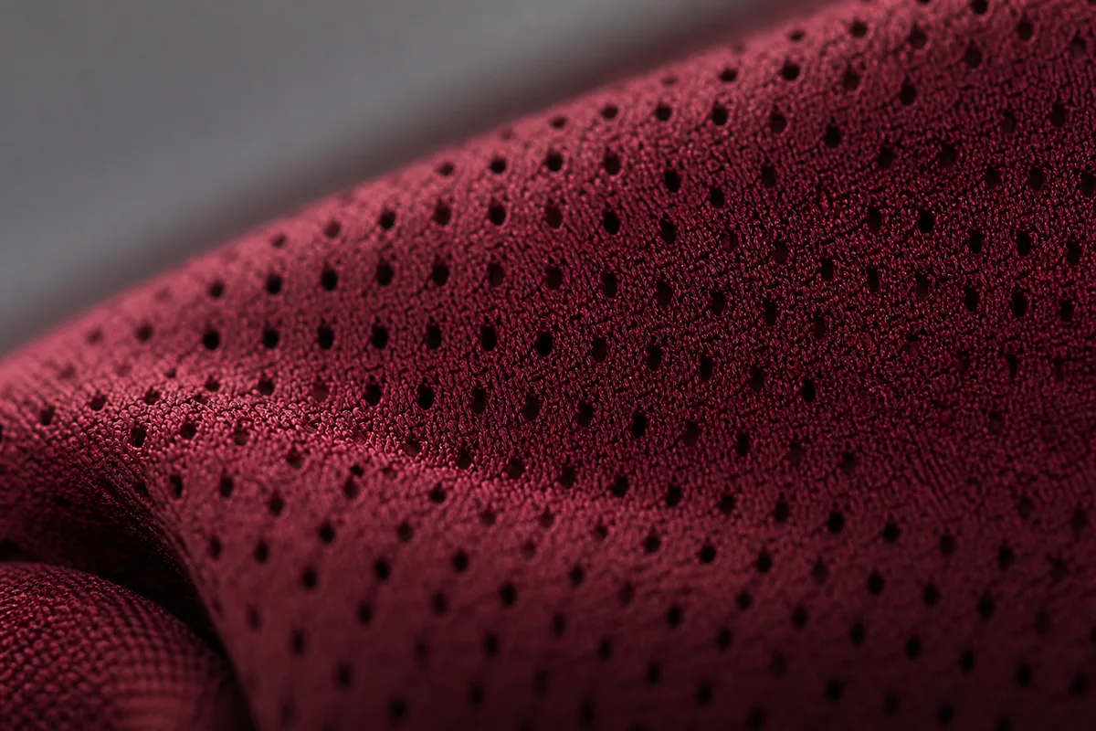 Gros plan sur la maille technique perforée d&rsquo;un maillot de football sportif